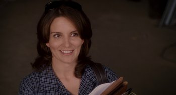 Movie still from “Baby Mama” (2008), directed by Michael McCullers – A woman holding a book and smiling for the camera; Close Up shot, Over the shoulder angle