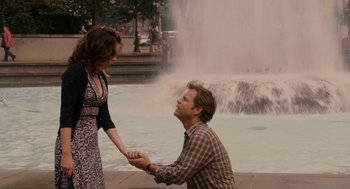Movie still from “Baby Mama” (2008), directed by Michael McCullers – A man kneeling down next to a woman in front of a fountain; Medium shot, Over the shoulder angle