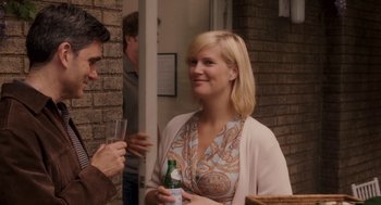 Movie still from “Baby Mama” (2008), directed by Michael McCullers – A woman is holding a bottle of beer and a man is holding a wine glass; Medium shot, Over the shoulder angle