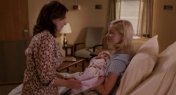 Movie still from “Baby Mama” (2008), directed by Michael McCullers – Two women are holding a baby in a room; Medium shot, Over the shoulder angle