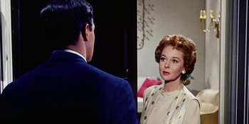 Movie still from “Back Street” (1961), directed by David Miller – A man and a woman are standing next to each other; Close Up shot, Over the shoulder angle