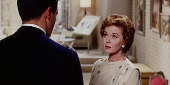 Movie still from “Back Street” (1961), directed by David Miller – An older woman in a white dress and a man in a blue suit; Close Up shot, Over the shoulder angle