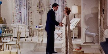 Movie still from “Back Street” (1961), directed by David Miller – A man and a woman shaking hands in a living room; Wide shot, Low angle