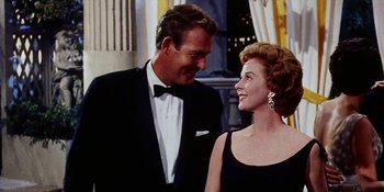 Movie still from “Back Street” (1961), directed by David Miller – A man and a woman standing next to each other; Medium shot, Low angle