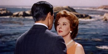 Movie still from “Back Street” (1961), directed by David Miller – A man and a woman standing next to each other near a body of water; Close Up shot, Over the shoulder angle