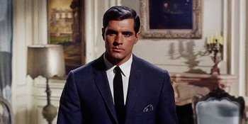 Movie still from “Back Street” (1961), directed by David Miller – A man wearing a suit and tie in a room; Close Up shot, Low angle