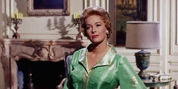Movie still from “Back Street” (1961), directed by David Miller – An older woman wearing a green dress in front of a painting; Medium shot, Low angle