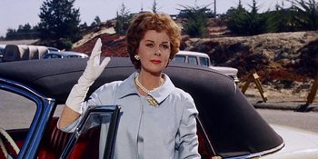 Movie still from “Back Street” (1961), directed by David Miller – An older woman standing in the back of a car; Medium shot, Low angle
