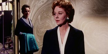 Movie still from “Back Street” (1961), directed by David Miller – A woman in a black jacket standing next to another woman in a white top; Medium shot, Low angle
