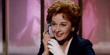 Movie still from “Back Street” (1961), directed by David Miller – An older woman talking on a cell phone wearing gloves; Close Up shot, Low angle