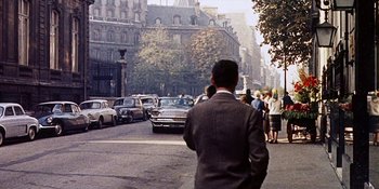 Movie still from “Back Street” (1961), directed by David Miller – A man is walking down the street in a suit; Extreme Wide shot, Over the shoulder angle