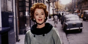 An old photo of an older woman in a gray coat