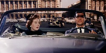 Movie still from “Back Street” (1961), directed by David Miller – A man and a woman sitting in the back seat of a car; Medium shot, Over the shoulder angle