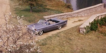 Movie still from “Back Street” (1961), directed by David Miller – An old car parked on the side of the road; Extreme Wide shot, High angle