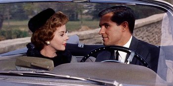 Movie still from “Back Street” (1961), directed by David Miller – A man and a woman sitting in the back seat of a car; Close Up shot, Over the shoulder angle