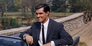 Movie still from “Back Street” (1961), directed by David Miller – A man wearing a suit and tie sitting on a motorcycle; Close Up shot, High angle