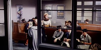 Movie still from “Back Street” (1961), directed by David Miller – A group of people sitting in a room with a window open; Wide shot, High angle