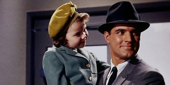 Movie still from “Back Street” (1961), directed by David Miller – A man and a little girl wearing hats and a suit; Close Up shot, Low angle