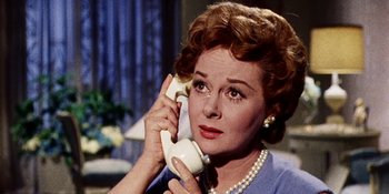 Movie still from “Back Street” (1961), directed by David Miller – An older woman talking on a phone while wearing pearls; Close Up shot, Low angle