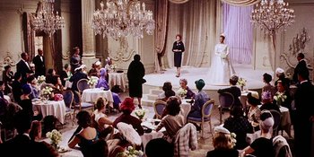 Movie still from “Back Street” (1961), directed by David Miller – A group of people sitting in a room with tables and chairs; Wide shot, High angle