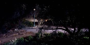 Movie still from “Back Street” (1961), directed by David Miller – A street light in the middle of a park at night; Extreme Wide shot, High angle