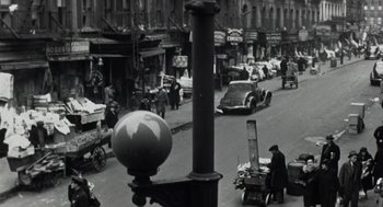Movie still from “Back to School” (1986), directed by Alan Metter – An old photo of a city street with cars and people; Extreme Wide shot, High angle