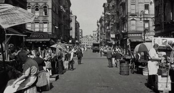 Movie still from “Back to School” (1986), directed by Alan Metter – A black and white photo of people walking down a street; Extreme Wide shot, High angle