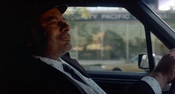 Movie still from “Back to School” (1986), directed by Alan Metter – A man sitting in the back seat of a car looking out of the window; Close Up shot, Over the shoulder angle