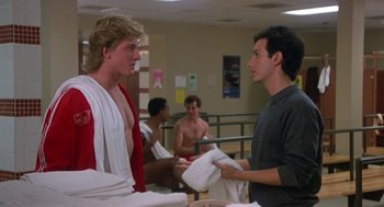 Movie still from “Back to School” (1986), directed by Alan Metter – Two young men in a gym exchanging towels; Medium shot, Over the shoulder angle