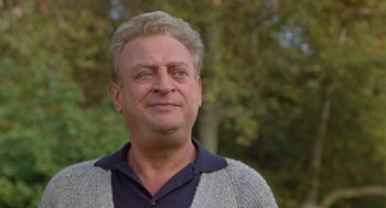 Movie still from “Back to School” (1986), directed by Alan Metter – A person wearing a sweater with trees in the background; Close Up shot, Low angle