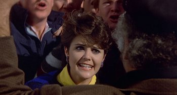 Movie still from “Back to School” (1986), directed by Alan Metter – A person with a crowd of people; Close Up shot, Over the shoulder angle