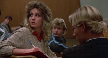 Movie still from “Back to School” (1986), directed by Alan Metter – Three people sitting at a table in a classroom; Close Up shot, Over the shoulder angle
