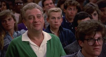 Movie still from “Back to School” (1986), directed by Alan Metter – An older man in a crowd of young men; Close Up shot, Low angle