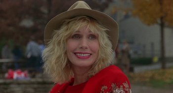 Movie still from “Back to School” (1986), directed by Alan Metter – A woman in a red shirt wearing a brown hat; Close Up shot, Low angle