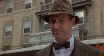 Movie still from “Back to School” (1986), directed by Alan Metter – A man wearing a hat and a bow tie in front of a building; Close Up shot, Low angle