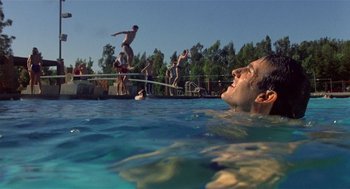 Movie still from “Back to School” (1986), directed by Alan Metter – A group of people in a pool jumping into the water; Wide shot, Low angle