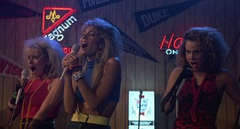 Movie still from “Back to School” (1986), directed by Alan Metter – A woman singing into a microphone in a bar; Medium shot, Low angle