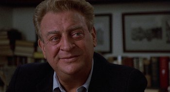 Movie still from “Back to School” (1986), directed by Alan Metter – A person wearing a suit and tie; Close Up shot, Over the shoulder angle