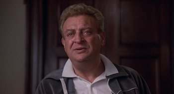 Movie still from “Back to School” (1986), directed by Alan Metter – An older man wearing a white shirt and a gray jacket; Close Up shot, Low angle