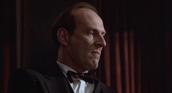 Movie still from “Back to School” (1986), directed by Alan Metter – A man in a suit and a bow tie; Close Up shot, Low angle