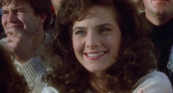 Movie still from “Back to School” (1986), directed by Alan Metter – A person with curly brown hair; Close Up shot, Over the shoulder angle