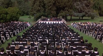 Movie still from “Back to School” (1986), directed by Alan Metter – A large group of people sitting on top of a lawn; Extreme Wide shot, High angle