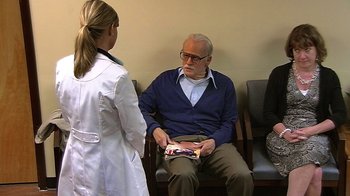 Movie still from “Jackass Presents: Bad Grandpa” (2013), directed by Jeff Tremaine – A woman in a white lab coat is talking to an older man; Wide shot, Over the shoulder angle