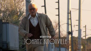 Movie still from “Jackass Presents: Bad Grandpa” (2013), directed by Jeff Tremaine – A man walking down the street in a brown jacket; Wide shot, Low angle