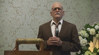 Movie still from “Jackass Presents: Bad Grandpa” (2013), directed by Jeff Tremaine – An older man in a suit and tie holding a microphone; Medium shot, Low angle