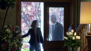 Movie still from “Jackass Presents: Bad Grandpa” (2013), directed by Jeff Tremaine – A woman standing in front of an open door with a man in a suit; Wide shot, Over the shoulder angle