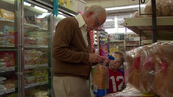 Movie still from “Jackass Presents: Bad Grandpa” (2013), directed by Jeff Tremaine – An older man and a young boy in a grocery store; Medium shot, Over the shoulder angle