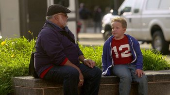 Movie still from “Jackass Presents: Bad Grandpa” (2013), directed by Jeff Tremaine – A man sitting next to a young boy on a bench; Medium shot, Over the shoulder angle