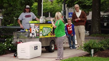 Movie still from “Jackass Presents: Bad Grandpa” (2013), directed by Jeff Tremaine – A woman standing in front of an ice cream cart; Medium shot, Over the shoulder angle