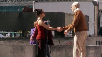Movie still from “Jackass Presents: Bad Grandpa” (2013), directed by Jeff Tremaine – A woman and a man shaking hands on a sidewalk; Medium shot, Over the shoulder angle